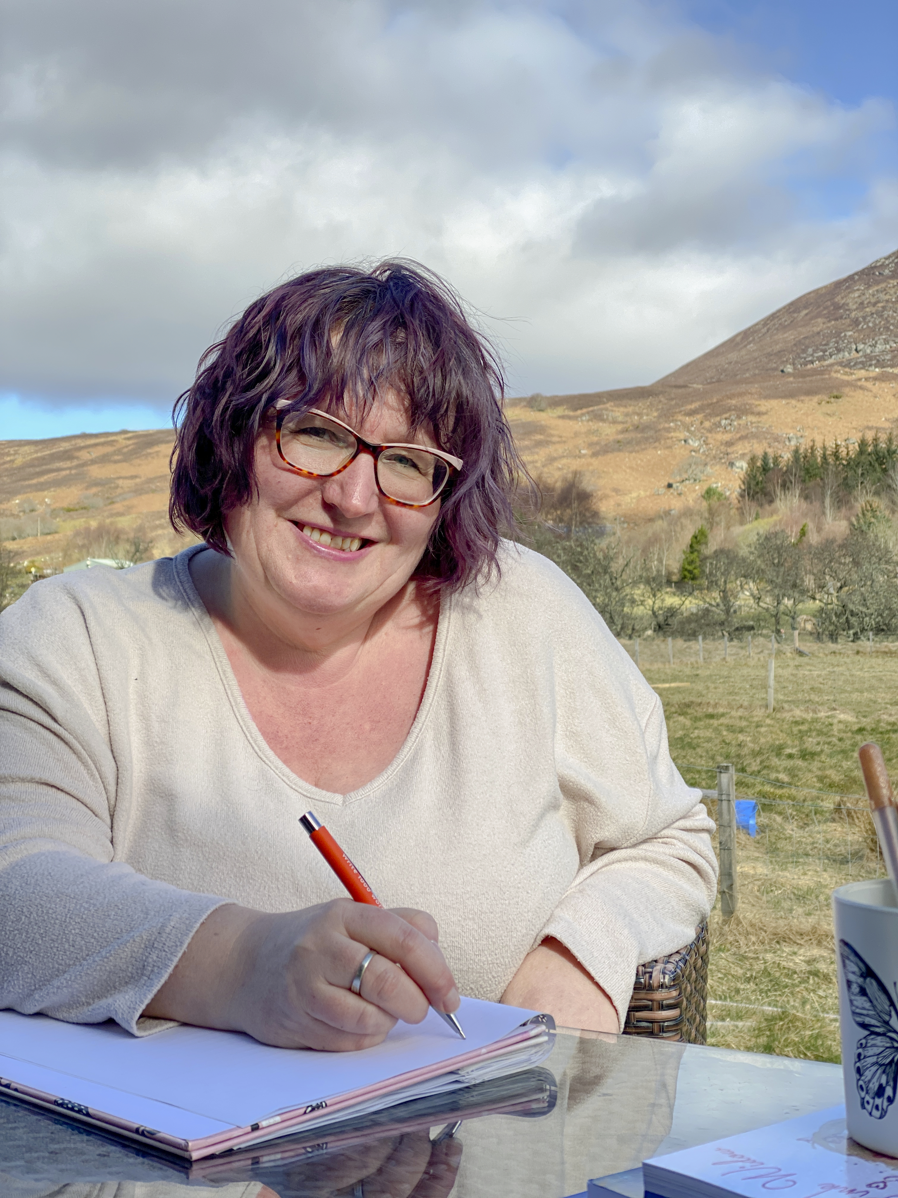 claire sat by a table writing in the highlands of scotland